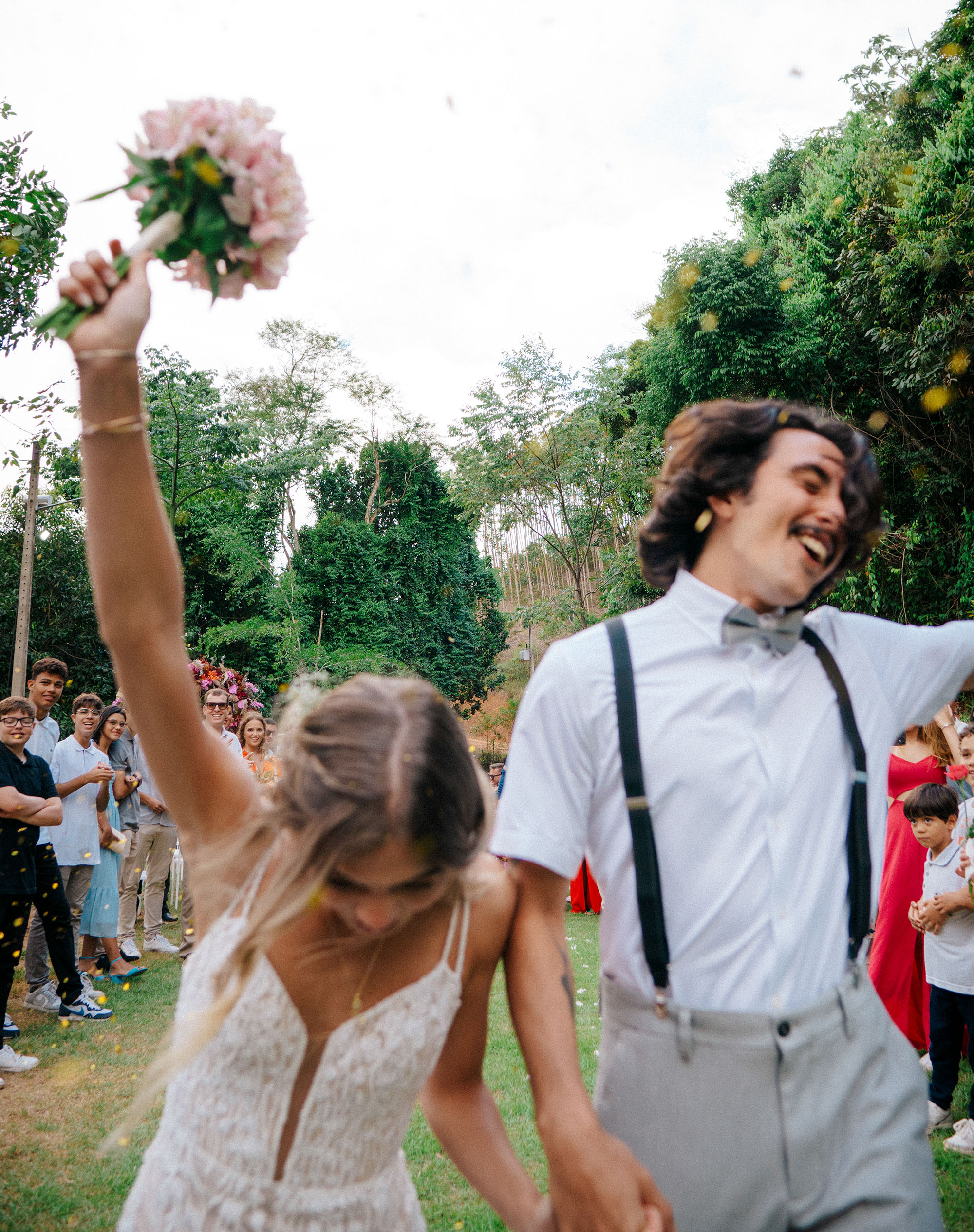 Buquê em primeiro plano durante momento de confete no casamento